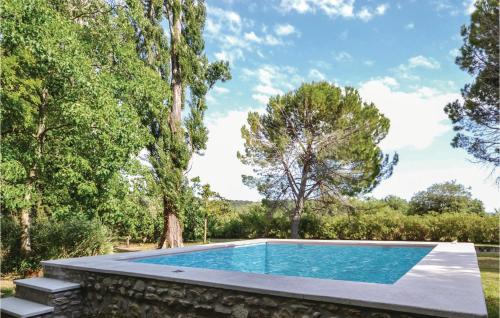 a swimming pool in a garden with trees at Lovely Home In Montbrison-Sur-Lez in Montbrison-sur-Lez