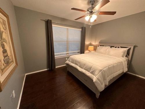 a bedroom with a bed with a ceiling fan and a window at Lake Front Home, around 15 minutes drive to AT&T and Epic Water in Grand Prairie