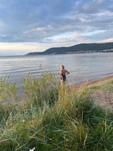 a man standing on a beach near the water at LillaStugan in Jönköping