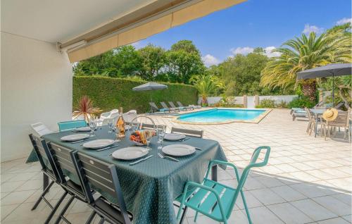 a blue table with chairs and a pool at Beautiful Home In Lège-Cap-Ferret in Lège-Cap-Ferret