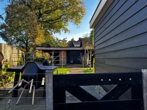 a black fence with a grill in front of a house at Luxe Vakantiehuis met privé Wellness in Zuidwolde