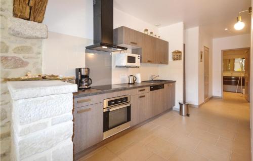 une cuisine avec une cuisinière et un micro-ondes dans l'établissement Lovely Home In Montbrison-Sur-Lez, à Montbrison-sur-Lez