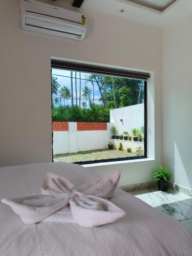 a bedroom with a bed with a pink bow on it at Wavealokam Beach Retreat in Varkala