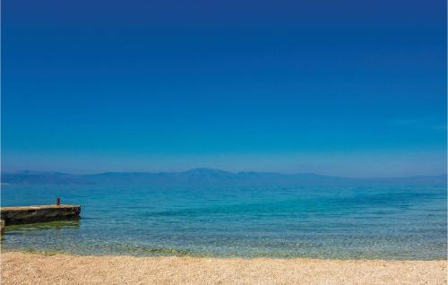 a beach with blue water and a pier at Lovely Apartment In Vantacici in Vantačići