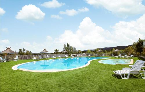 a large swimming pool with chairs and a lawn at 2 Bedroom Awesome Home In Grospierres in Grospierres