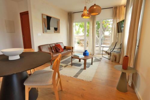 a living room with a table and a couch at Octopus House Caparica in Costa da Caparica