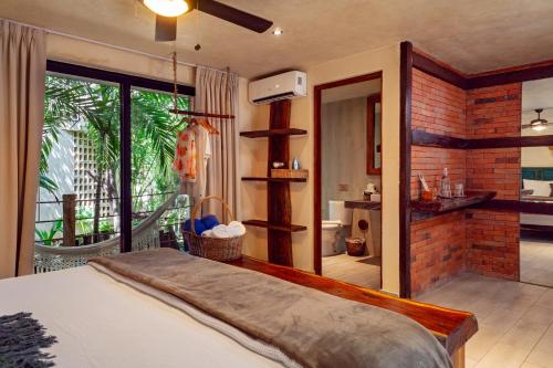 a bedroom with a bed and a bathroom with a balcony at Sunset House in Tulum