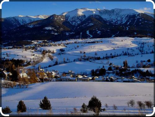 a town covered in snow with mountains in the background at Chalet des loulous , 3 chambres, 8 couchages in Font Romeu Odeillo Via