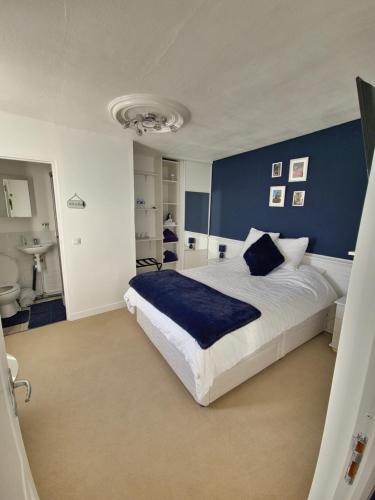 a bedroom with a large bed and a blue wall at Sycamore House in Laurière