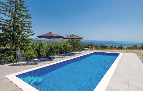 a swimming pool with chairs and umbrellas on a house at Gorgeous Home In Bregi With Kitchen in Breza