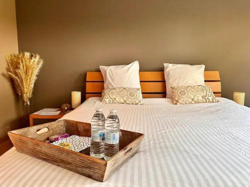 a bed with a tray of water bottles on it at La maison noire au coin in Bruges
