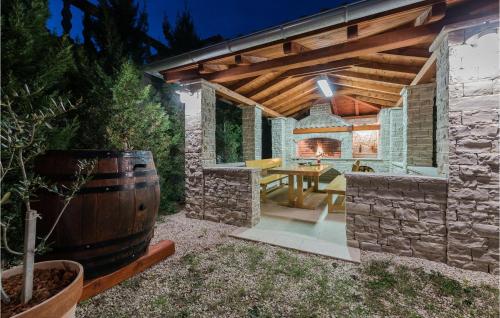 an outdoor patio with a table and a barrel at Amazing Home In Vrsi With Wifi in Vrsi