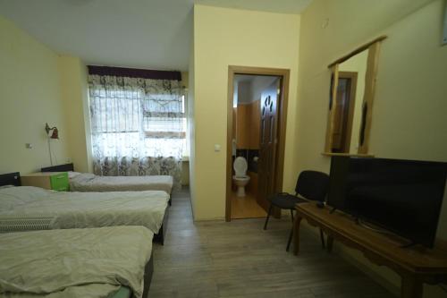 a hotel room with two beds and a television at Romblast Srl in Găgeni