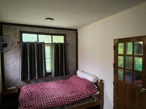 un dormitorio con una cama y una ventana en Cozy house near the sea, en Koh Samui 