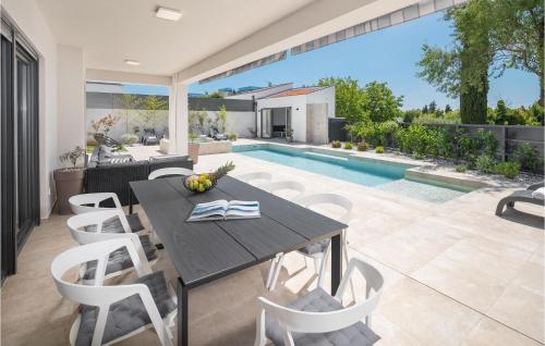 a dining room with a table and chairs and a pool at Cozy Home In Banjole With Wifi in Banjole
