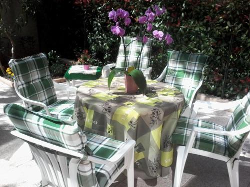 d'une table et de chaises avec une table et des fleurs. dans l'établissement Studio Rénové en Rez de Jardin Climatisé, à Cannes