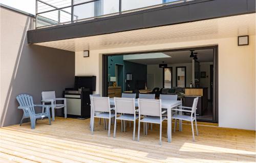 a dining room with a table and chairs on a deck at Cozy Home In Stjean De Monts in Saint-Jean-de-Monts