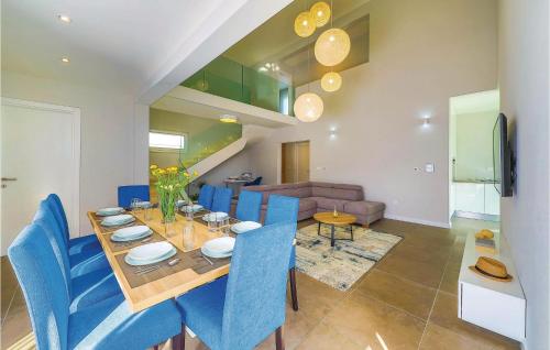 ein Esszimmer mit einem Tisch und blauen Stühlen in der Unterkunft Five-Bedroom Holiday Home In Kastel Kambelovac in Kaštela