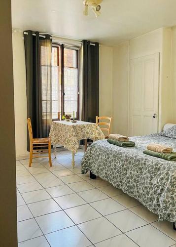 une chambre avec deux lits et une table et des chaises dans l'établissement L'Aquarium, parking gratuit, garage moto et vélo, à Talloires