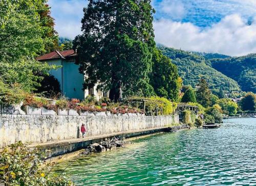 a bridge over a river next to a body of water at L'Aquarium, parking gratuit, garage moto et vélo in Talloires