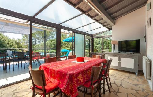 une salle à manger avec une table avec des chaises et une télévision dans l'établissement Beautiful Home In Signes, à Signes
