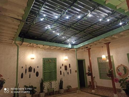 a room with a ceiling with green doors and lights at Hostal Prana in Abejorral