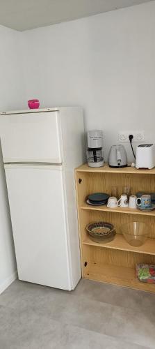 Il comprend une cuisine équipée d'un réfrigérateur blanc et d'une étagère. dans l'établissement Studio indépendant de plain pied agréé Chèques Vacances, à Drancy