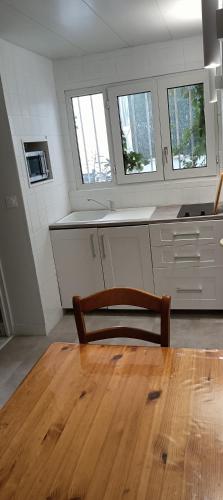 une cuisine avec une table et un fauteuil en bois dans l'établissement Studio indépendant de plain pied agréé Chèques Vacances, à Drancy