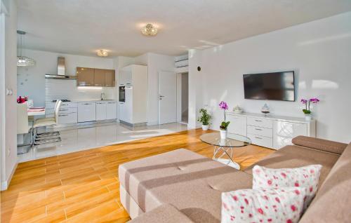 a living room with a couch and a table and a kitchen at 3 Bedroom Stunning Home In Bogomolje in Bogomolje