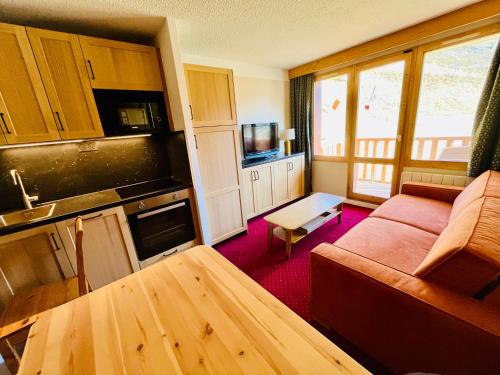 un petit salon avec un canapé et une cuisine dans l'établissement NOUVEAU à BELLE PLAGNE - Pieds des pistes et ESF !, à Belle Plagne