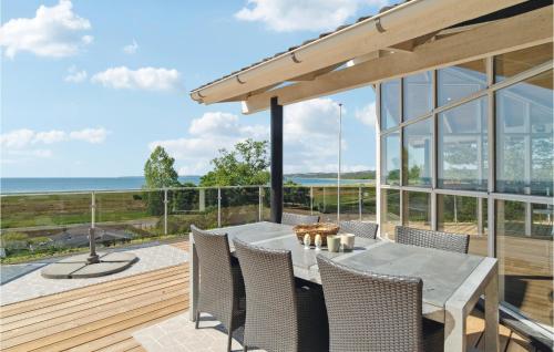 a patio with a table and chairs and the ocean at Holiday Home Klitvej Ebeltoft X in Ebeltoft