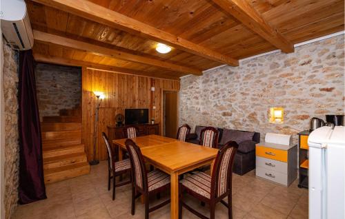 jadalnia z drewnianym stołem i krzesłami w obiekcie Gorgeous Home In Lisane Tinjske w mieście Lišane Tinjske