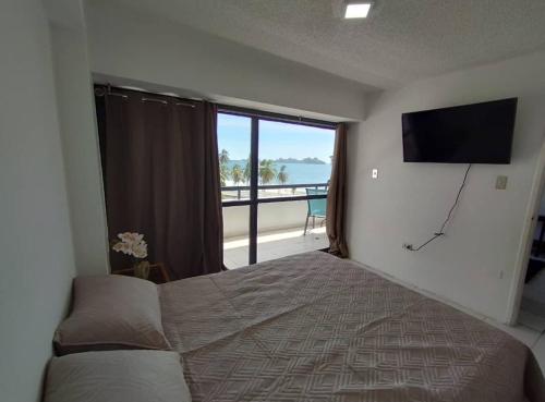 ポルラマルにあるMENINA Beach Apartmentのベッドと薄型テレビのある寝室