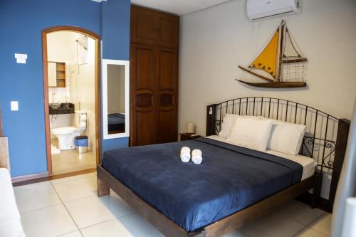 a bedroom with a bed with a sailboat on the wall at Pousada Quintal do Mar in Ubatuba