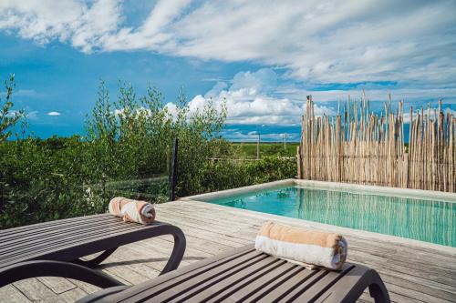 a wooden deck with a bench next to a swimming pool at Sunset House in Tulum