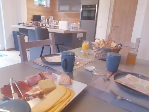 a table with a plate of cheese and bread on it at B&B Caprice d'Epices in Francorchamps
