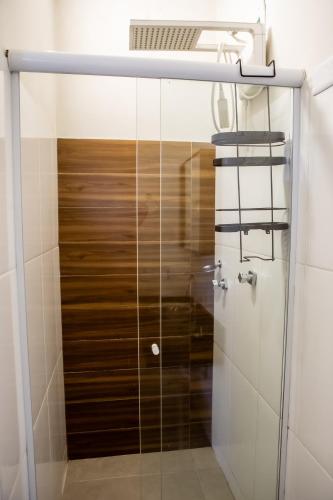 a shower with a glass door in a bathroom at Pousada Quintal do Mar in Ubatuba