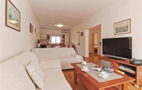a living room with two white couches and a tv at Holiday Home Put Vrljuge Iv in Sukošan