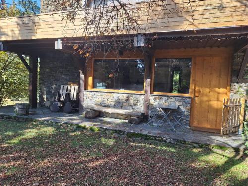 un porche d'une maison avec un mur de pierre dans l'établissement refugio en el bosque, à La Molina