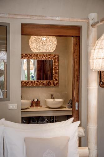 a bathroom with two sinks and a mirror at The Deck Cottages Samui in Bophut