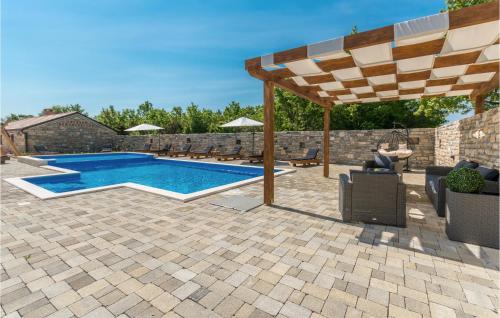 a patio with a swimming pool and an umbrella at Lovely Home In Perusic Donji With Wifi in Dušić