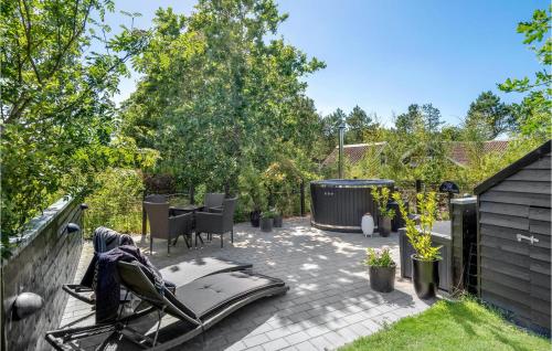 SkjernにあるNice Home In Skjern With Kitchenの裏庭のパティオ(テーブル、椅子付)