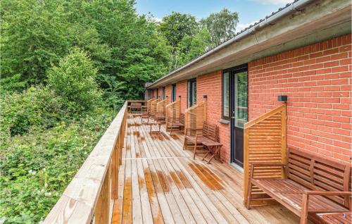 a row of benches sitting on a wooden deck at 1 Bedroom Nice Apartment In Svaneke in Svaneke