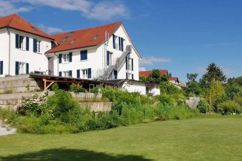 a large white house with a red roof at In DE preiswert wohnen und in der CH gut verdienen in Klettgau