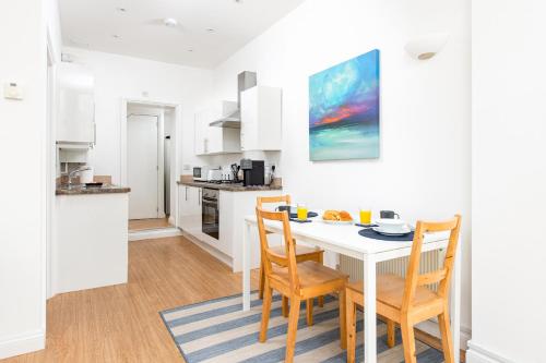 a kitchen and dining room with a white table and chairs at Large 1 bed Flat-Long Stays-By MatchstickStays in Bristol