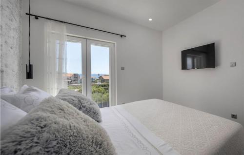 a white bedroom with a white bed with a window at Nice Home In Sucuraj With Wifi in Sućuraj