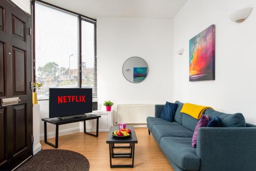 a living room with a blue couch and a tv at Large 1 bed Flat-Long Stays-By MatchstickStays in Bristol
