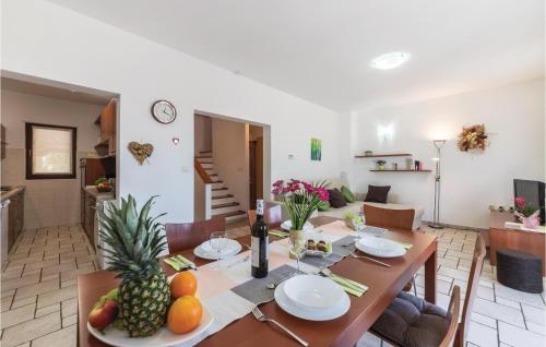 a dining room and living room with a table with fruit on it at Awesome Home In Fazana With Kitchen in Fažana