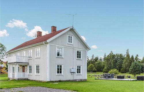 a white house with a red roof on a field at Gorgeous Home In Braås With Kitchen in Braås