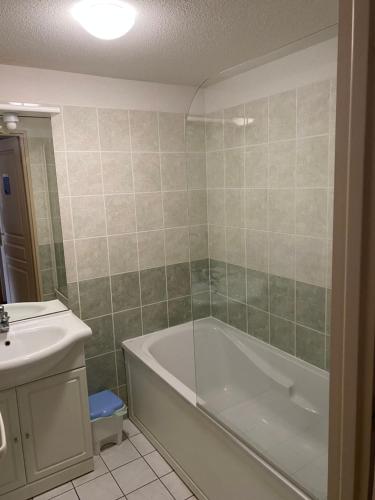 une salle de bain avec une baignoire et un lavabo dans l'établissement Chez Adelaïde, à Levernois